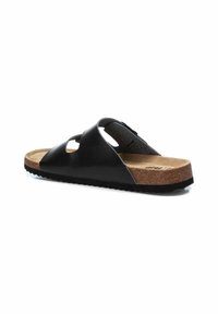 Sandalia deslizante de cuero negro con correas recortadas, plantilla de corcho y suela de goma texturizada. Diseño plano, estilo casual.