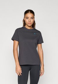 Szürke, rövid ujjú póló, kerek nyakkivágással és egy kis kék logóval a bal mellrészen. Puha, sima anyag, laza fit.