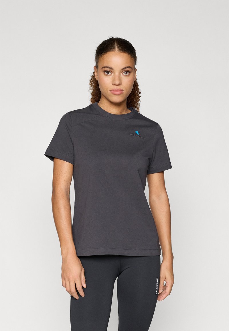 Camiseta gris de manga corta con un escote redondo y un pequeño logo azul en el lado izquierdo del pecho. Tela suave y lisa con un corte relajado.