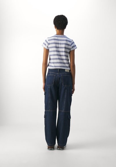 Cămașă cu mânecă scurtă, cu dungi albastre și albe, asortată cu o pereche de pantaloni cargo din denim de un bleu închis, cu buzunare laterale.