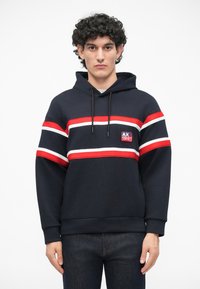 Sudadera azul marino con capucha, con rayas horizontales rojas y blancas, parche de logo en el pecho y puños y dobladillo acanalados.