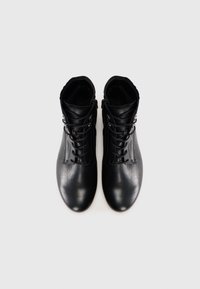 Pair of black leather ankle boots with laces and side zippers, shown from above on a plain light background.