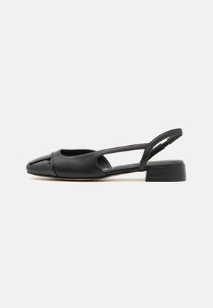 Chaussure slingback en cuir noir avec un bout arrondi, présentant un cap en verni et un petit talon bloc. Texture lisse et détails de design minimalistes.