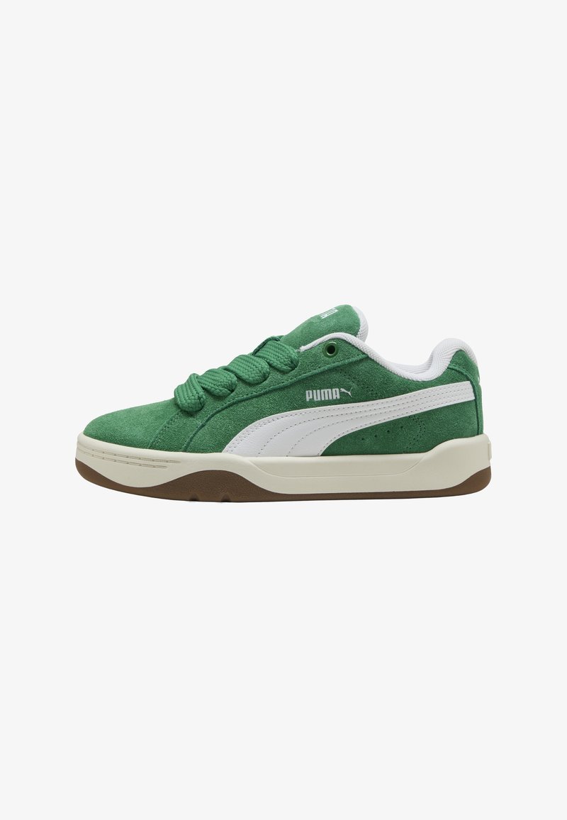 Baskets Puma en daim vert avec bande blanche, lacets verts épais, col rembourré et semelle beige à empreinte marron.