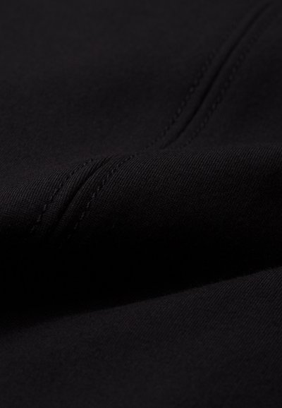Black fabric with a soft texture and visible stitching lines; exhibits a smooth, slightly stretchy appearance with a matte finish.