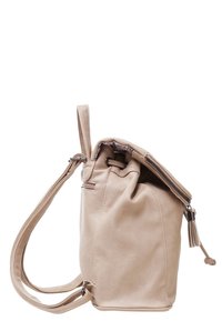 Sac à dos en cuir beige avec des bretelles réglables, fermeture éclair supérieure partiellement ouverte, et un petit détail de pompon sur la tirette de la fermeture.
