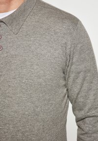 Grey long-sleeve polo shirt with a textured knit finish, featuring a classic collar and three button closure on the neck.
