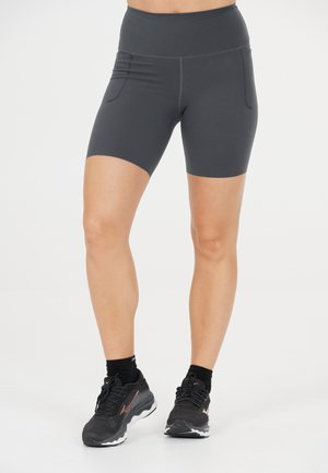 Högmidjade mörkgrå shorts i stretchmaterial med två sidfickor och slät yta, tillsammans med svarta träningssneakers och strumpor.