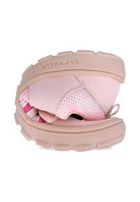 Zapatilla deportiva rosa con una suela de goma texturizada. Cuenta con paneles de malla, un diseño flexible y acentos elásticos para facilitar su uso.
