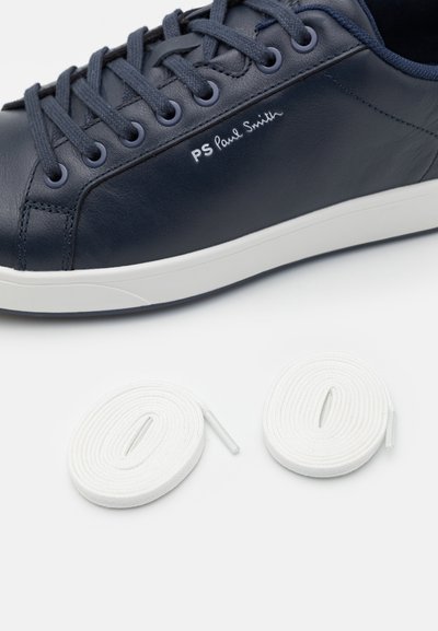 Marinblå lädersneakers med vit sula, med marinblå snören och logodetalj. Inkluderar två vita skosnören rullade prydligt bredvid skorna.
