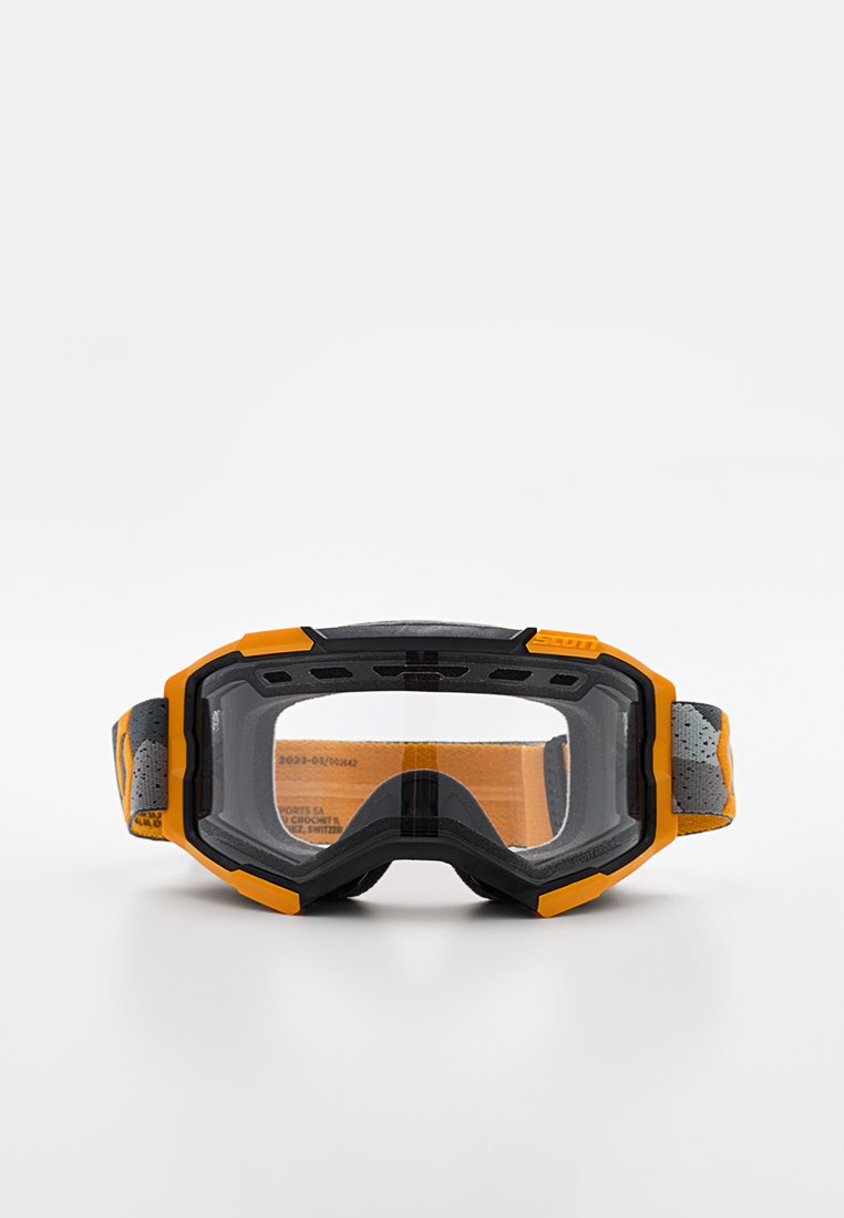 Gafas de protección con un marco de caucho negro y amarillo, lentes transparentes y una correa gris con diseño. Cuentan con un amplio campo visual y acolchado de espuma.