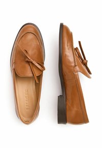 Hnědé kožené mokasíny s mašlovým detailem, plochá tmavá podrážka, pohled zepředu na jeden bota, pohled z boku na druhý, uvnitř viditelné značení značky.