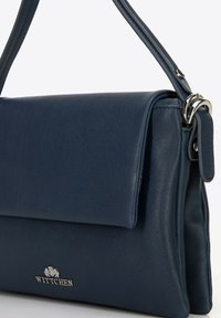 Granatowa skórzana torebka z podłożonym klapą, srebrnymi akcentami i strukturalnym designem; wyposażona w pasek na ramię i detale z logo.