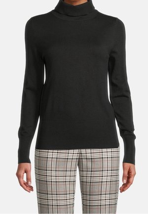 Pull noir à manches longues et col roulé, associé à un pantalon à carreaux beige, noir et rouge taille haute, porté par une personne debout.