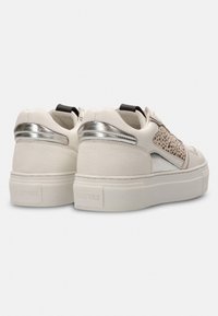 Witte sneakers met een gestructureerde afwerking, zilveren accenten en geperforeerde details aan de zijkanten. Voorzien van een chunky zool en branding op de hiel.