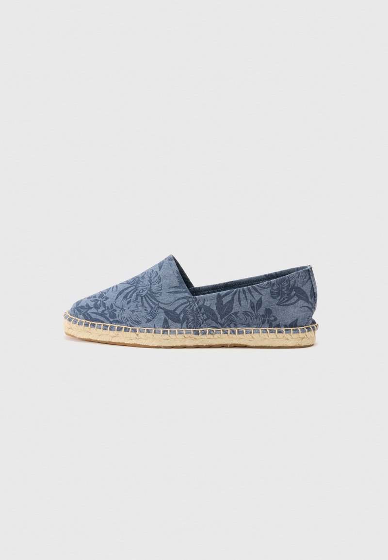 Espadrilă albastră cu un model floral, fabricată din material textil de tip canvas. Are o talpă din sfoară de jută și un design cu vârf rotund.
