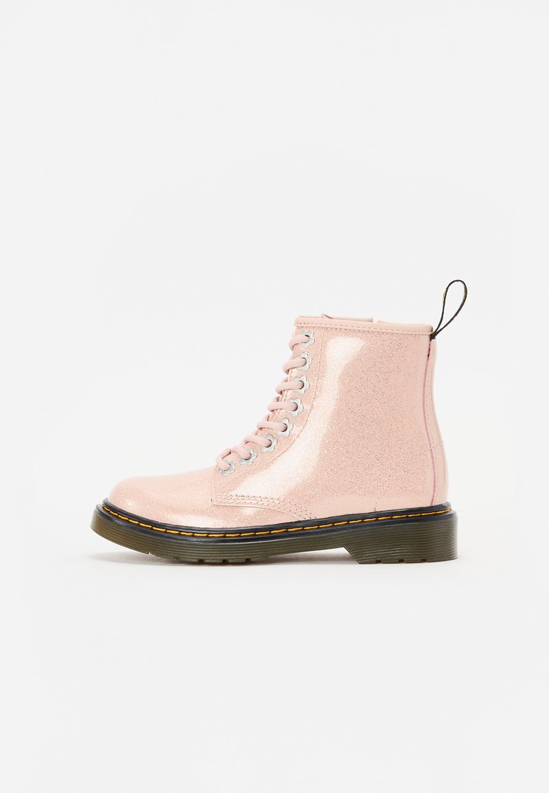 Roze glitter enkellaarsjes met een gladde afwerking, ronde neus, vetersluiting aan de voorkant, grijze oogjes en een zwarte gestructureerde zool. Verzegd met een treklip.