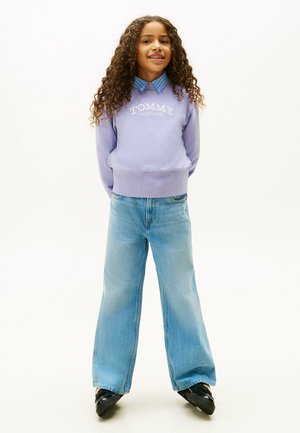 Lavendel sweatshirt med "TOMMY HILFIGER" logo, lyseblå knapkrave, højtaljede vidde jeans i blå og sorte sko.