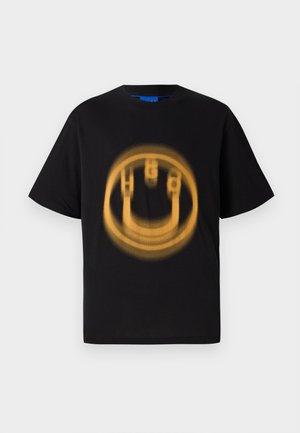 Camiseta de algodón negra con mangas cortas que presenta un gráfico circular, amarillento y desgastado de una cara sonriente en el frente.