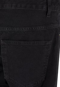 Črne denim hlače z enim zadnjim žepom in ravnim šivom. Tkanina ima mat teksturo in robustno konstrukcijo.