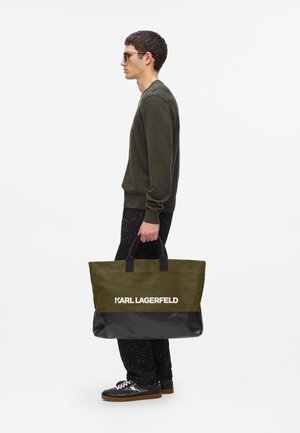 Oliwkowa torba na ramię z czarnym dnem, z podwójnymi uchwytami i wyraźnym białym logo "KARL LAGERFELD". Wytrzymały materiał z płótna.