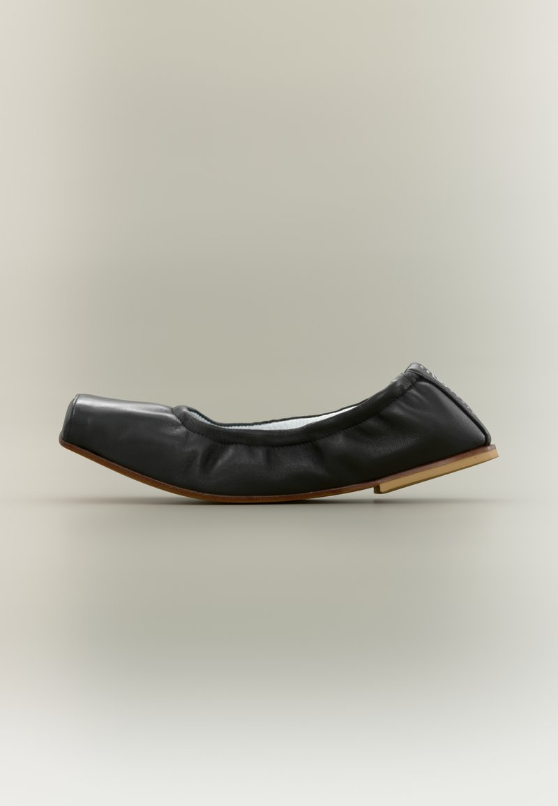 Μαύρο μαλακό δερμάτινο επίπεδο παπούτσι με τετράγωνη μύτη και ξύλινη σόλα, σχεδιασμένο για άνετο και εύκολο φορεμα.