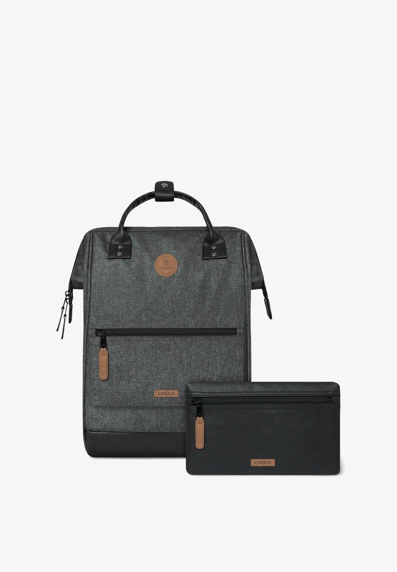 Grijze geweven stoffen rugzak met zwarte accenten, voorzien van een voorvak met rits en een afneembare zwarte tas. Bruin logo patch zichtbaar.