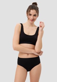 Schwarzer Sport-BH mit breiten Trägern und quadratischem Ausschnitt, kombiniert mit passenden schwarzen Unterhosen. Glattes Material, minimalistisches Design, keine sichtbaren Muster.