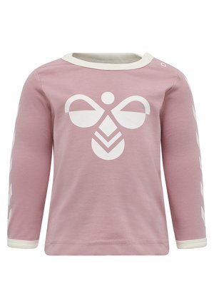 Chemise à manches longues rose en coton, ornée d'un grand graphique abstrait d'abeille blanche sur le devant et d'accents blancs sur les manches.