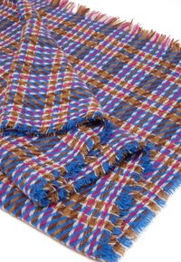 Manta tejida en marrón, azul, rosa y blanco con un patrón de cuadros geométrico; presenta bordes con flecos y una superficie suave y texturizada.
