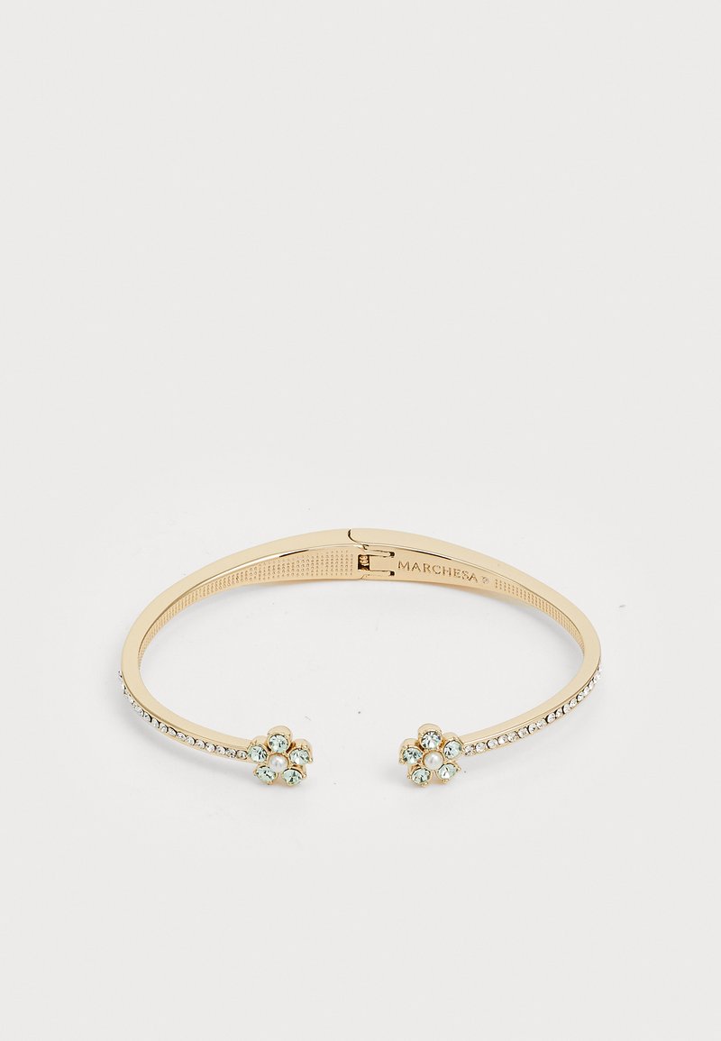 Zlatna narukvica s cvjetnim akcentima koja sadrži svijetloplave kamenčiće, prozirne kristale duž narukvice i sigurno kopčanje.