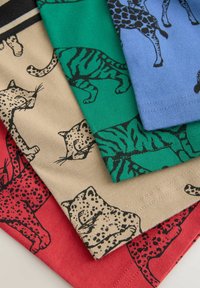 Fire t-shirts i forskellige farver: rød med leoparder, beige med jaguarer, grøn med tigre og blå med giraffer. Alle har dyreprints.