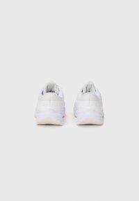 Zapatillas deportivas blancas con parte superior de tejido texturizado, cuello acolchado y suela de goma. Presentan un diseño minimalista y un branding sutil.