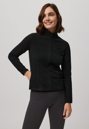 Chaqueta de forro polar negra con un collar alto y cremallera frontal. Presenta mangas largas y bolsillos laterales, con una silueta ajustada y textura suave.