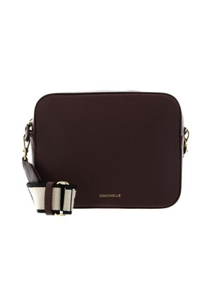 Sac bandoulière rectangulaire en cuir marron foncé avec pièces métalliques dorées et large sangle en tissu rayé noir et blanc réglable.