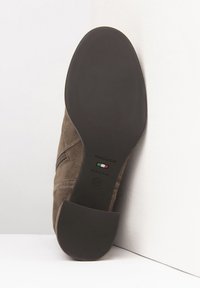 Brauner Wildleder-Stiefelette mit einer glatten schwarzen Gummisohle. Mit einem seitlichen Reißverschluss und Markierung auf der Sohle: "NeroGiardini, Made in Italy, 37."