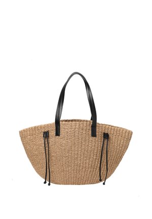 Sac fourre-tout en paille tissée avec des poignées en cuir noir et des cordons en cuir noir réglables sur les côtés.
