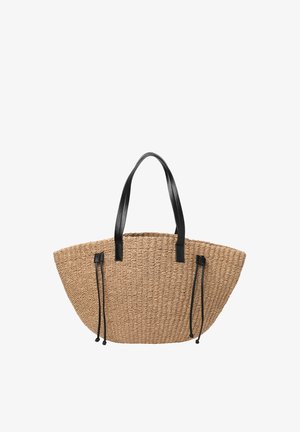 Sac fourre-tout en paille tissée avec des poignées en cuir noir et des cordons en cuir noir réglables sur les côtés.
