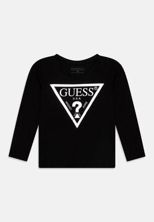 Tricou negru cu mânecă lungă, având un logo triunghiular mare reflectorizant în alb, cu nasturi pritentați la umăr pentru o îmbrăcare ușoară.