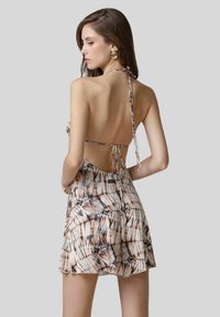 Abito con collo all'americana e schiena legata. Presenta un design a motivo in toni morbidi di beige, marrone e crema. Tessuto leggero e fluido.