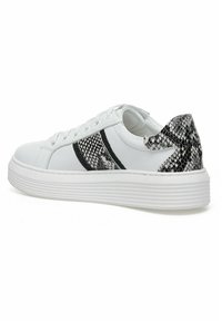 Baskets blanches avec un accent en imprimé serpent texturé noir et blanc sur le talon. Elles présentent une semelle plat blanche et des lacets, avec un dessus en cuir lisse.