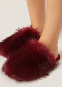 Burgundy fur slippers with fluffy texture, open back design, and rounded front. Soft, voluminous material covers the foot.