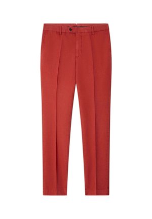 Pantalones a medida color óxido con trabillas para cinturón, cierre de botones, pliegues delanteros y bolsillos laterales, mostrados sobre fondo blanco.