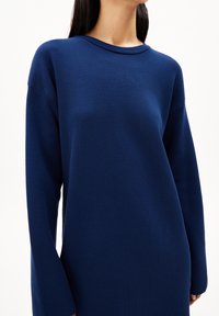 Pull à manches longues bleu marine en maille texturée, avec un col rond et des épaules tombantes pour une coupe décontractée.