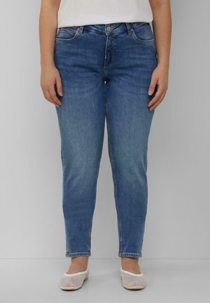 Blauwe denim jeans met een slim fit, middelhoge taille en subtiele vervaging. Gepaard met witte mesh flats voor een casual uitstraling.