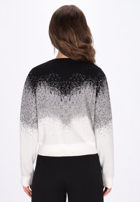 Pulover în degradé de negru la alb, cu detalii din paiete; textură moale de tricot, guler rotund și tiv ajustat. Mânici lungi cu manșete încrețite.