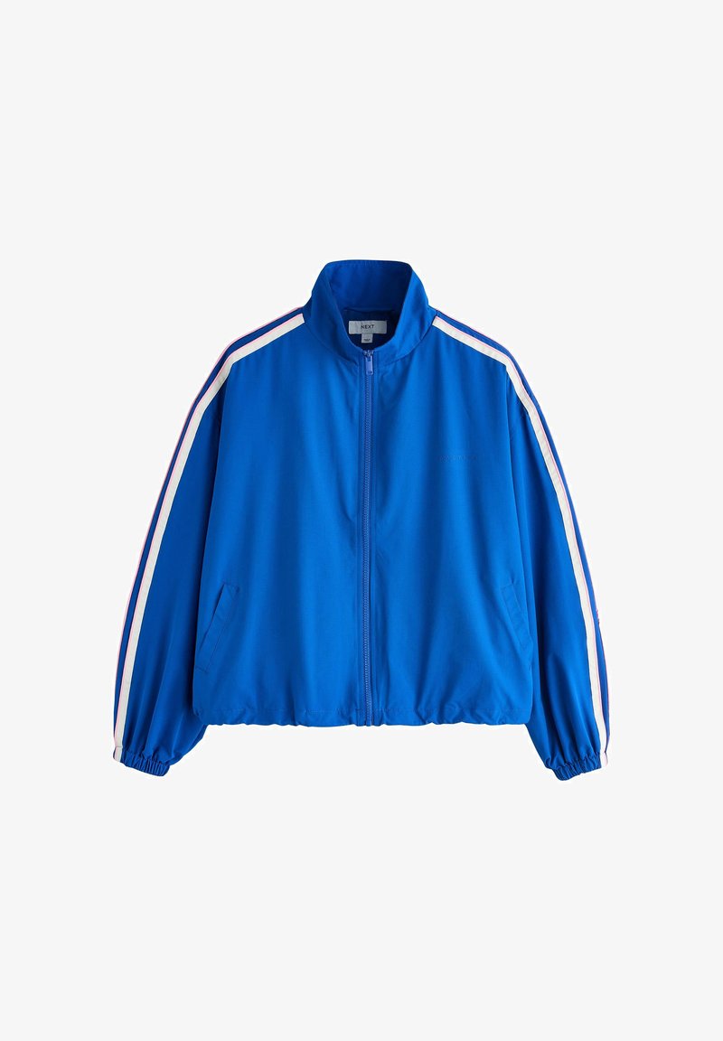 Veste de survêtement bleue à fermeture éclair avec des rayures blanches et rouges le long des manches, des poignets élastiques et des poches latérales.