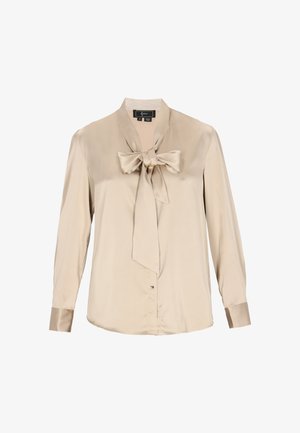 Beige satinbluse med lange ærmer og et sløjfebånd ved halsen. Har knaplukning og manchetter lavet af det samme satinmateriale.