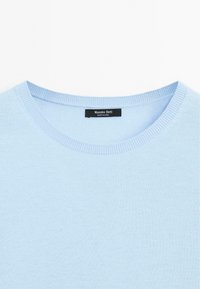 Light blue knitted sweater with a crew neckline. Features ribbed edges at the collar and hem. Label reads "Massimo Dutti." Soft texture.