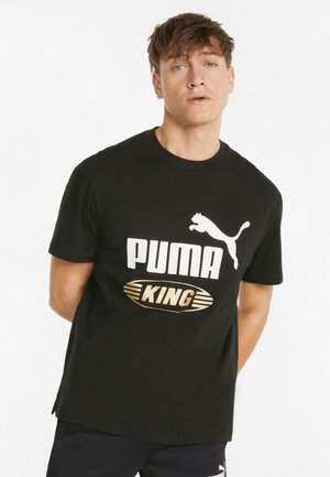 Svart bomull T-skjorte med korte ermer, med en stor hvit "PUMA"-logo og et gull "KING"-emblemet på fronten.